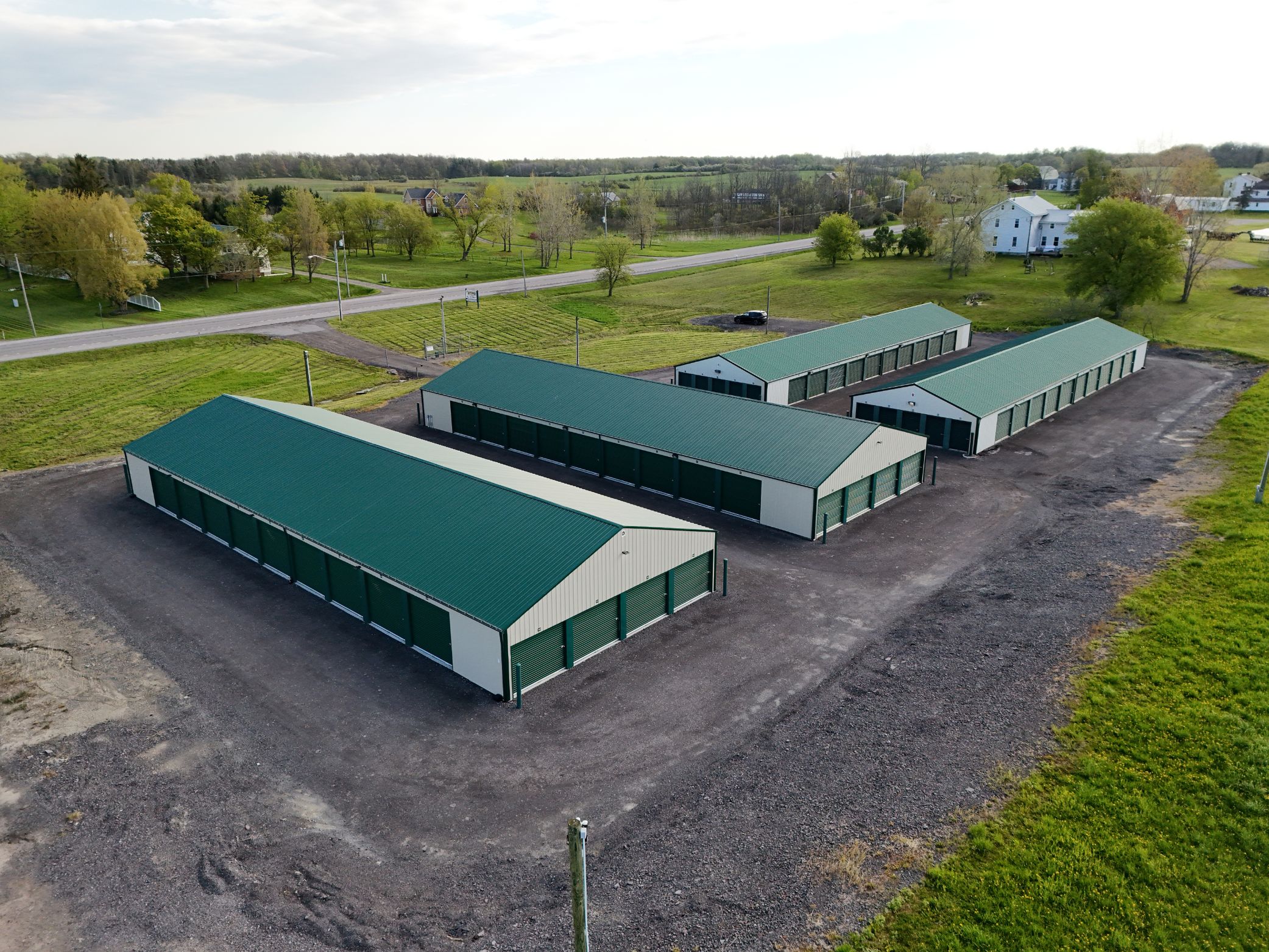 Aerial view of A-Verdi Self Storage facility with green-roofed storage buildings, gravel driveways, and rural homes nearby.